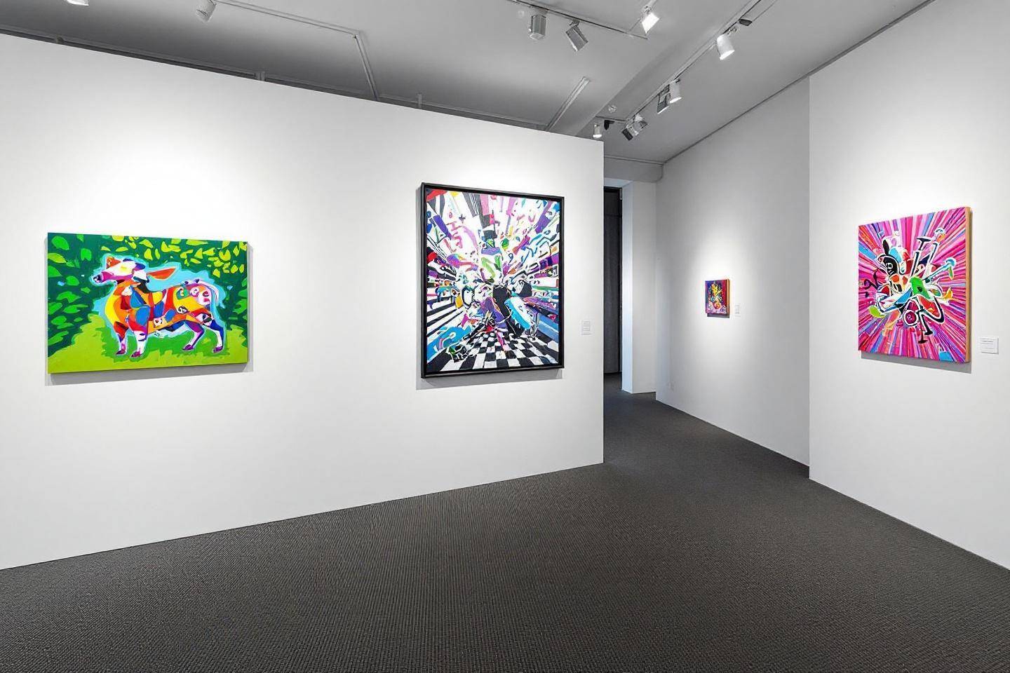 Quatre tableaux colorés exposés dans une galerie blanche minimaliste