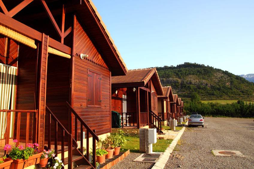Wooden bungalow row in camping camp park in mountains